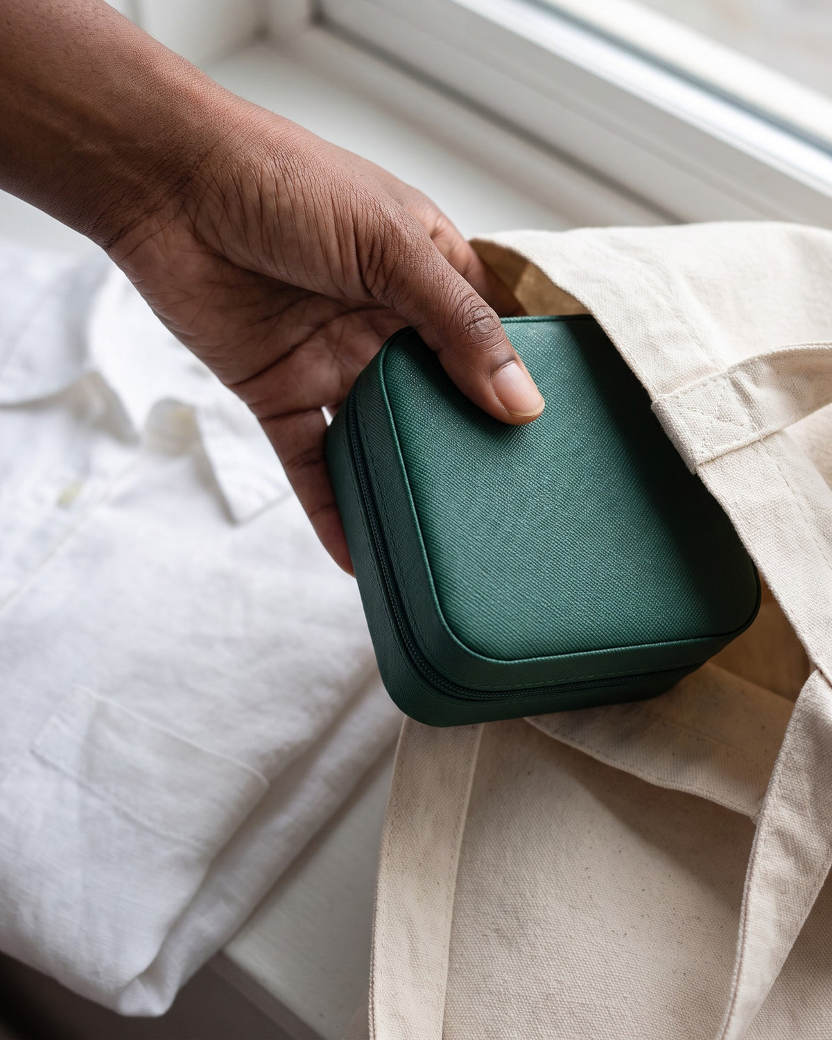 Main glissant l'écrin Havre Futaie fermé dans un sac en toile